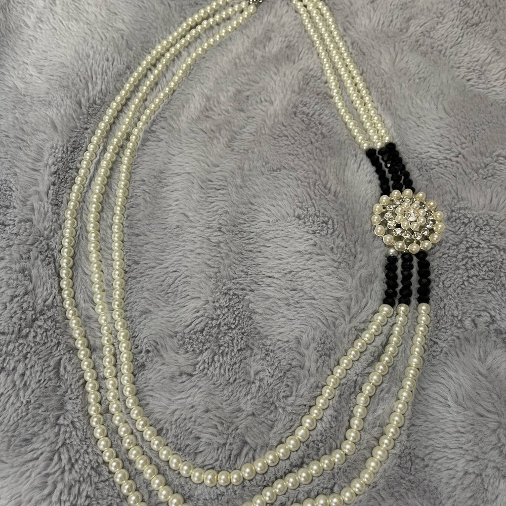 Faux pearl necklace with embellishment.